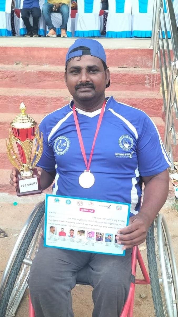 Abraham holding a trophy, a medal and a certificate