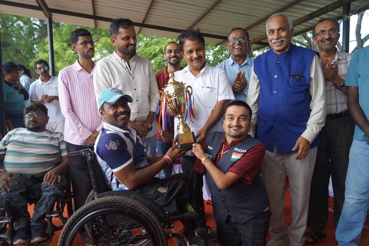 Ajit Padasalagi receiving a trophy among teammates and dignitaries