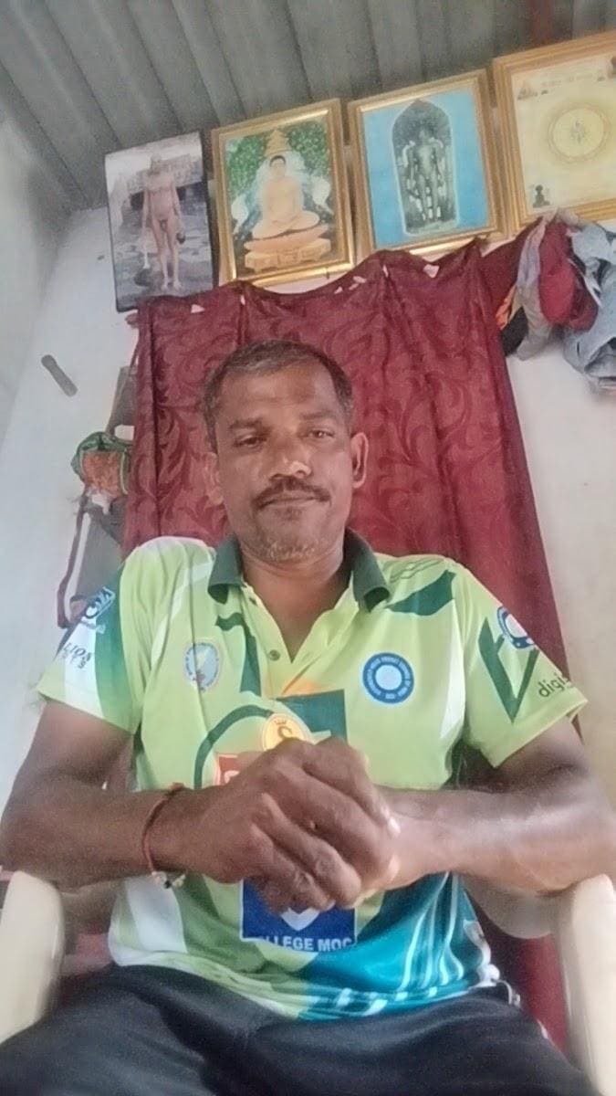 Bharatesh seated indoors in a green jersey