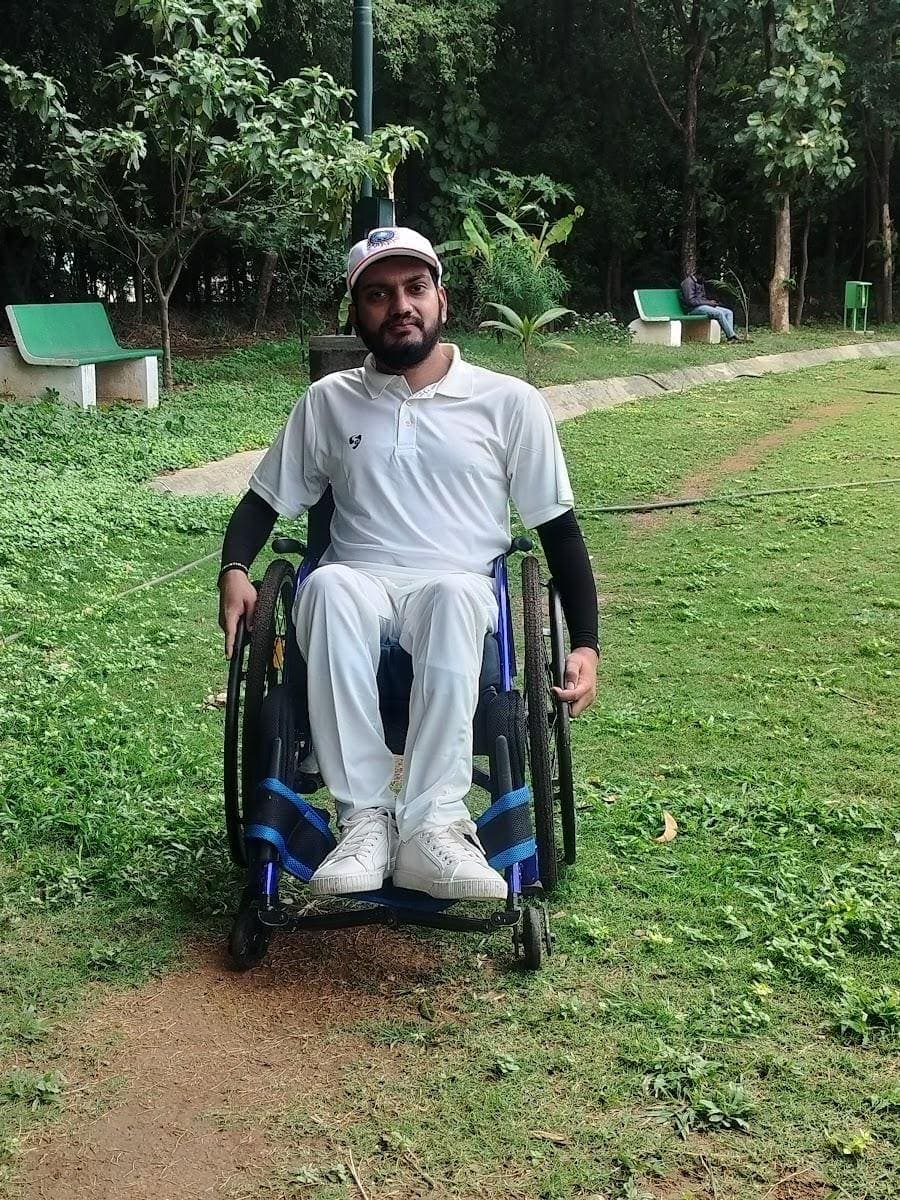 Mohammed Umar Manna in cricket whites in a sports wheelchair