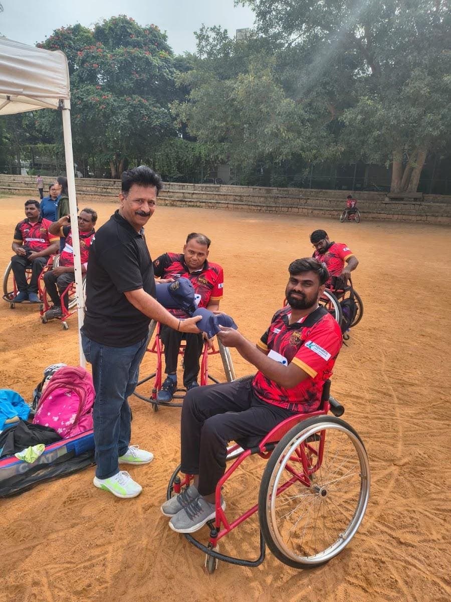 Sunil receiving a cap from a guest at the ground