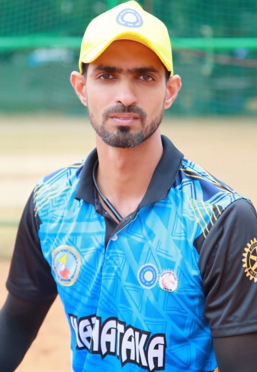 Portrait of Khaleel Ahmed in a Karnataka jersey and yellow cap