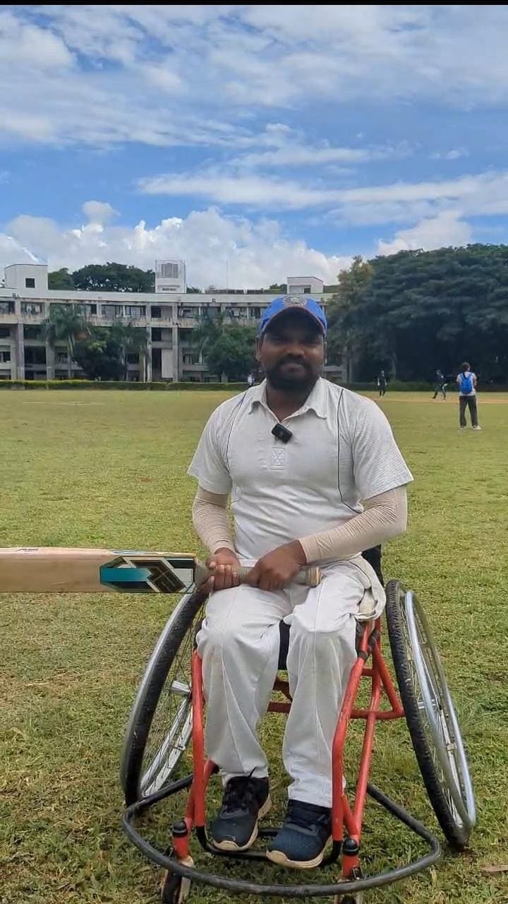 D. Sudhakar seated in a sports wheelchair on a cricket ground