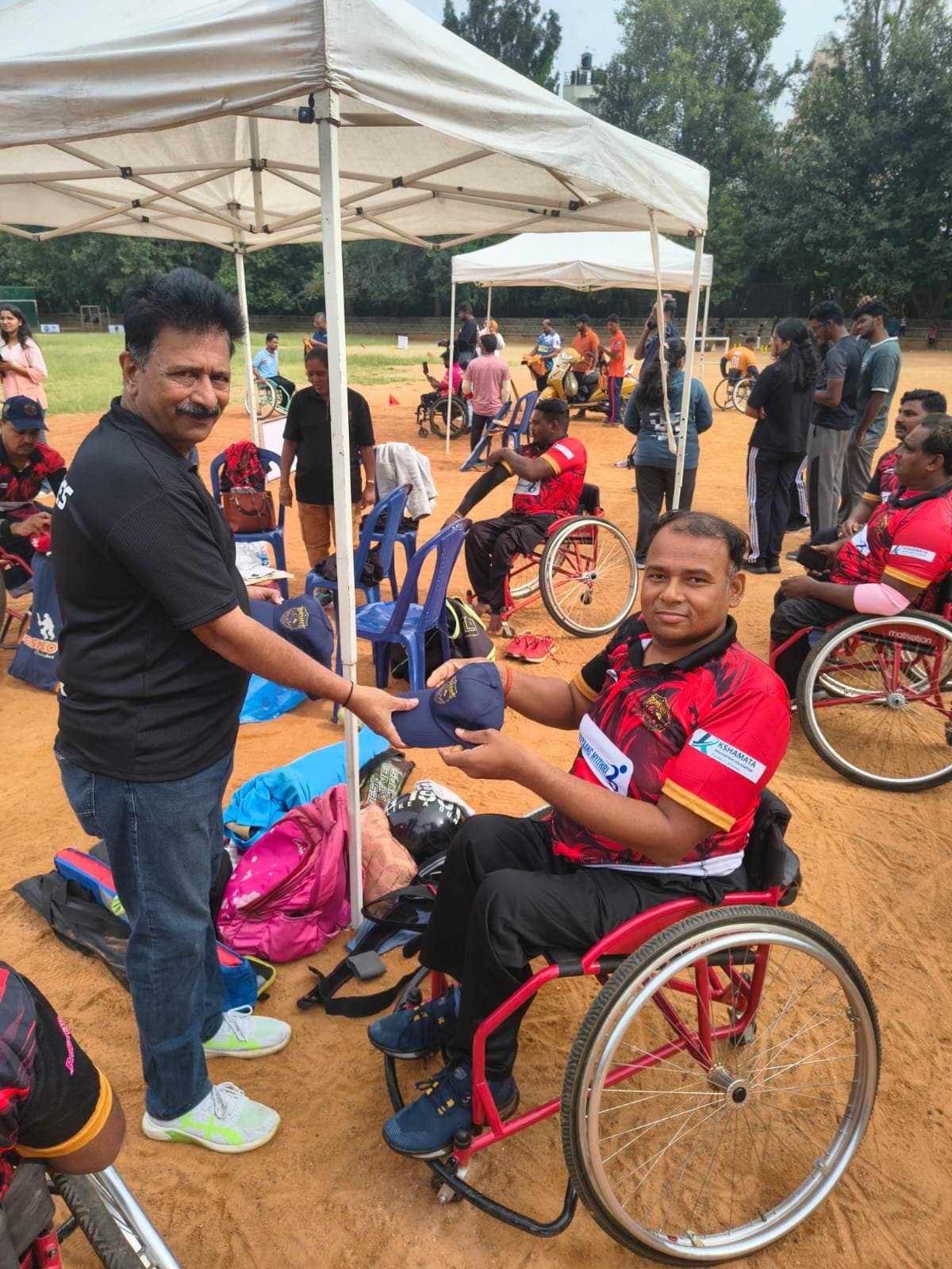 Rakesh Kumar Singh receiving a team cap at the ground