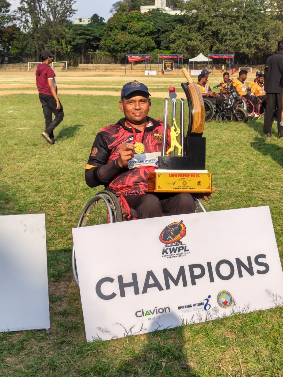 Rakesh Kumar Singh with the KWPL champions' trophy and a Champions sign